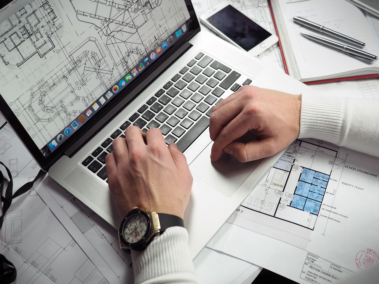 Blueprints, entrepreneur, hands — Stuart Piltch Insurance: Redefining Risk Management with Precision and Innovation
