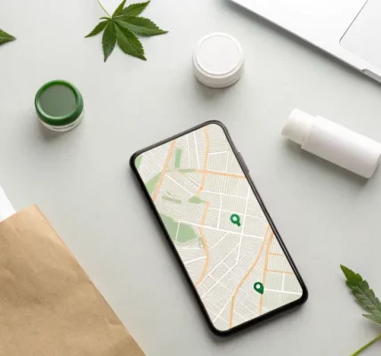 flat lay of a smartphone displaying a map next to cannabis products and a shopping bag